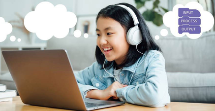 A young Techmentry student smiling with headphones during her live 1:1 online coding class, thinking through input, process and output blocks